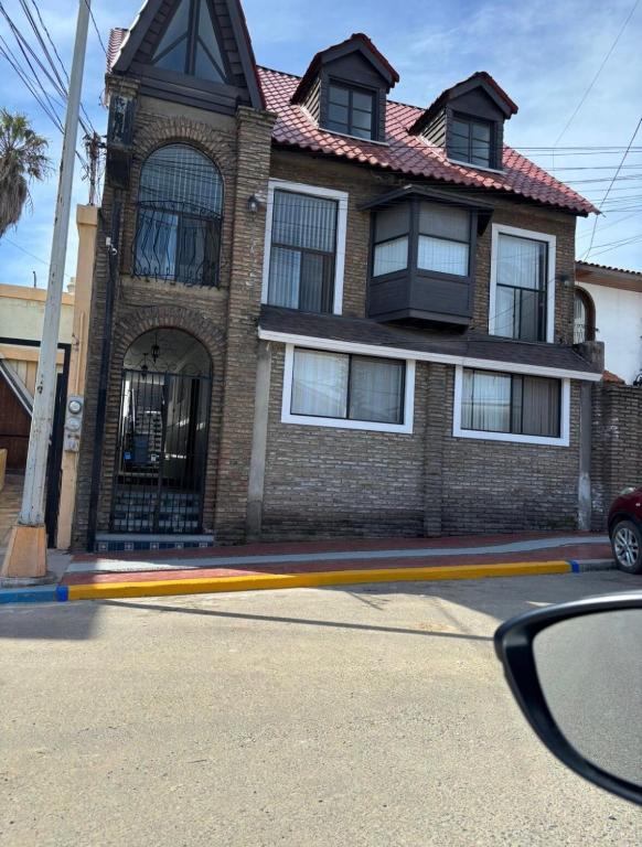 a brick house with a red roof on a street at Casa Vivanco apartment #5 in Ensenada