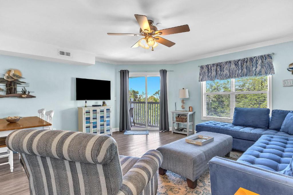 a living room with a blue couch and a tv at Dolphy Daze by Oak Island Accommodations in Oak Island