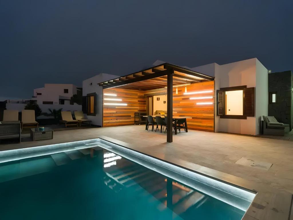 a house with a swimming pool next to a house at Casa Andrada in Yaiza