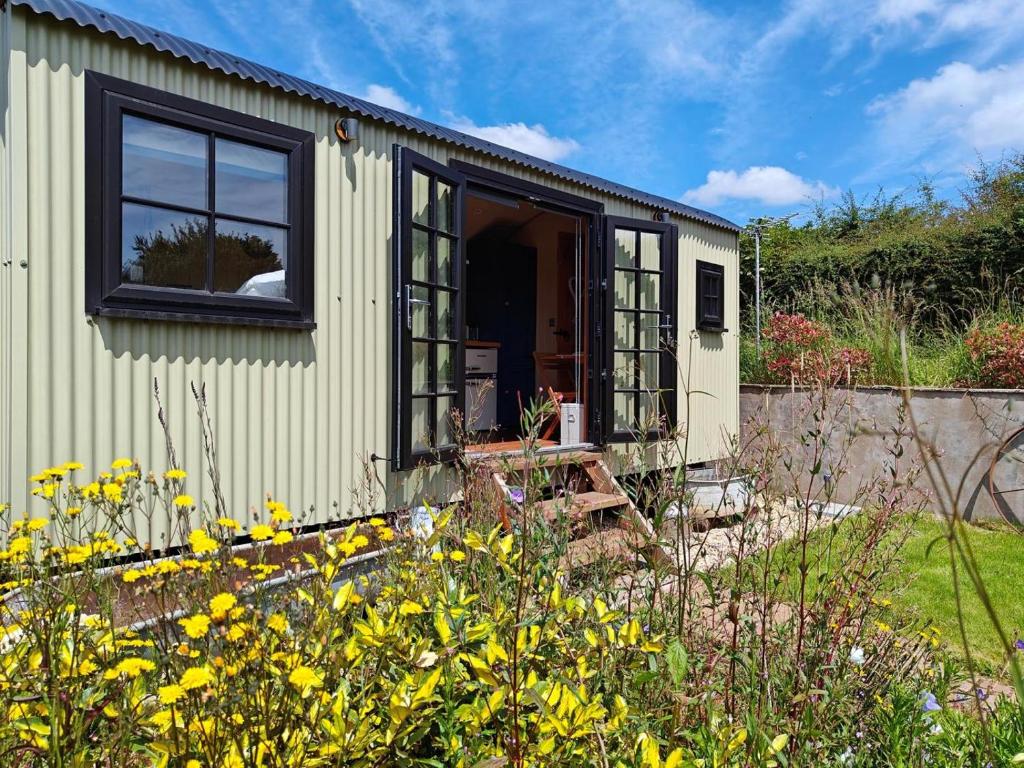 a tiny house in a garden with yellow flowers at 1 Bed in Lydney oc-85862 in Bream