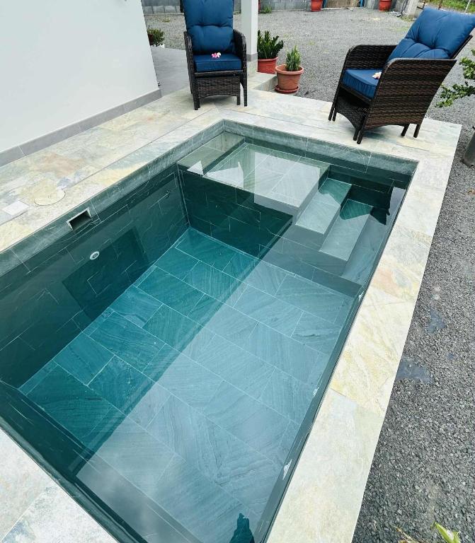 a swimming pool with blue tiles on top of it at Matirina Ura lodge in Arue