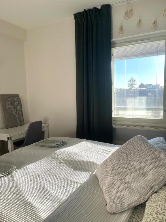 a bedroom with a bed and a window at Apartments Maaherrankatu in Kuopio