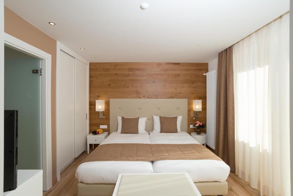 Postel nebo postele na pokoji v ubytování Hotel Schweizerhof Pontresina