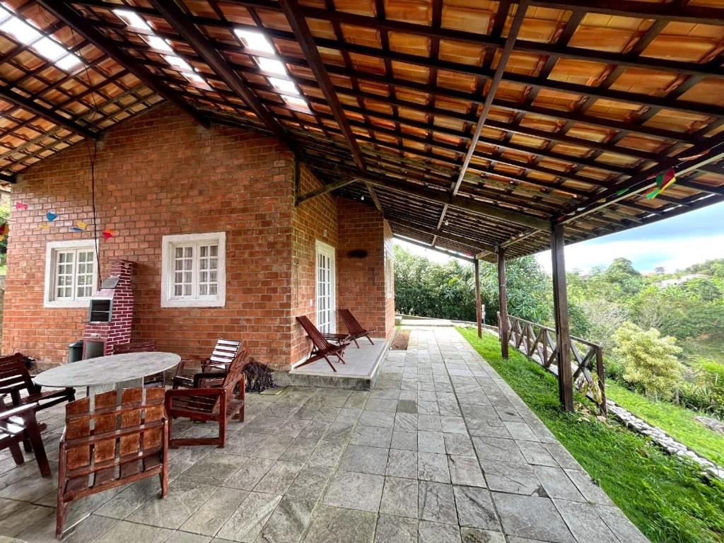 a patio with a table and chairs and a brick building at Chalés serra negra in Bezerros