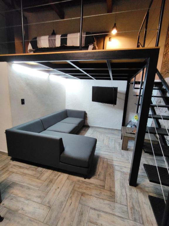 a living room with a couch and a loft bed at Casona Poblana Hotel Puebla in Puebla
