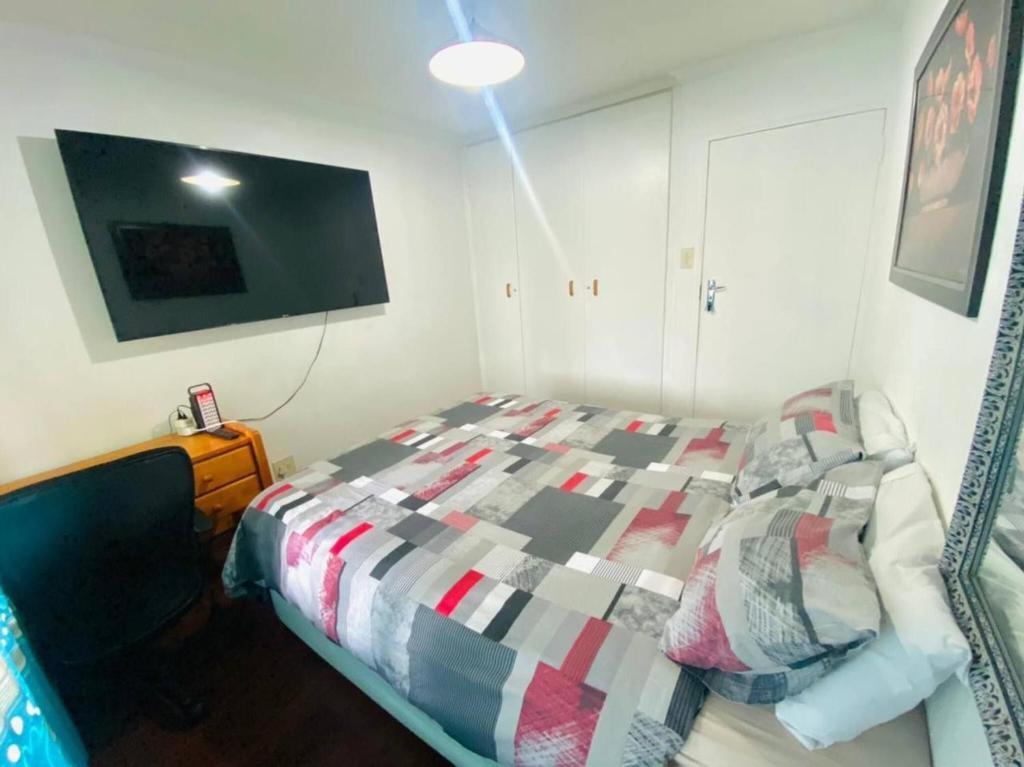 a bedroom with a bed and a flat screen tv at Premium Executive Room in Sandton