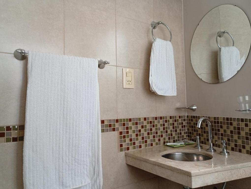 a bathroom with a sink and a mirror and a towel at El DESCANSO HOSPEDAJE in Resistencia