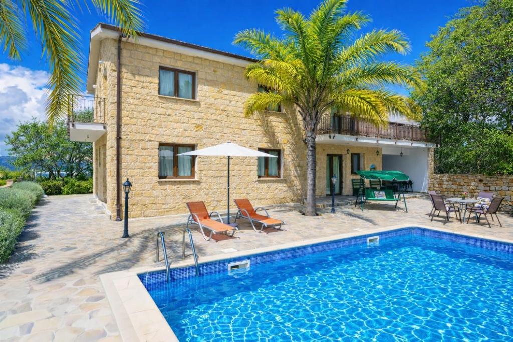 a swimming pool in front of a house at Villa Alonia in Simou