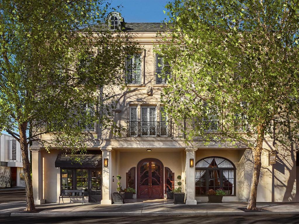 a large white building with a door and trees at Liora Estate in Healdsburg