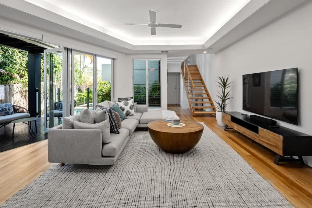 a living room with a couch and a coffee table at Modern airy duplex steps to River heated pool in Noosaville