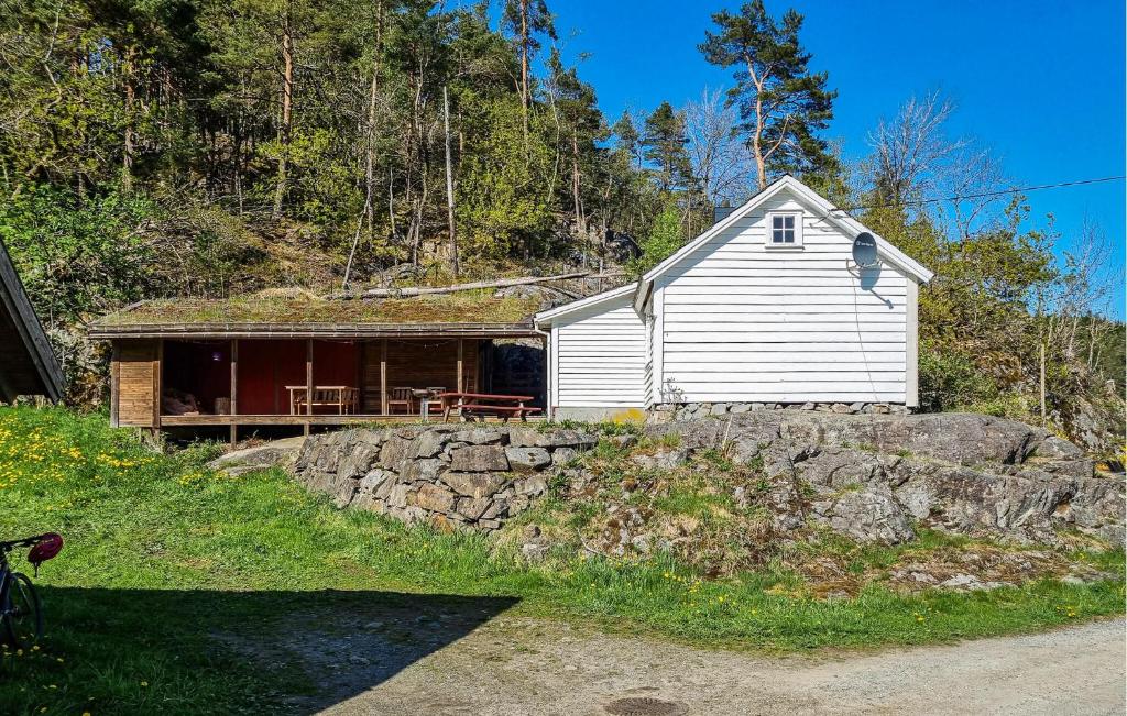 a house with a stone wall in front of it at Sjøhytta in Vanvik