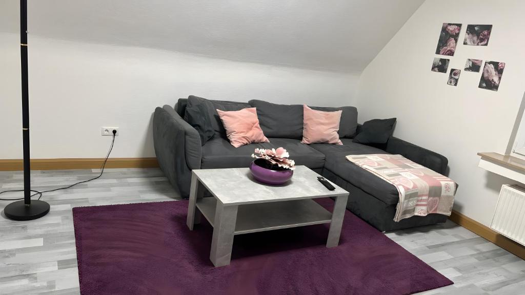 a living room with a couch and a table at Ferienwohnung auf dem Traumpfad in Ettringen
