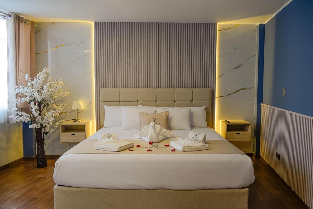 a bedroom with a large white bed with towels on it at Andari Hoteles in Arequipa