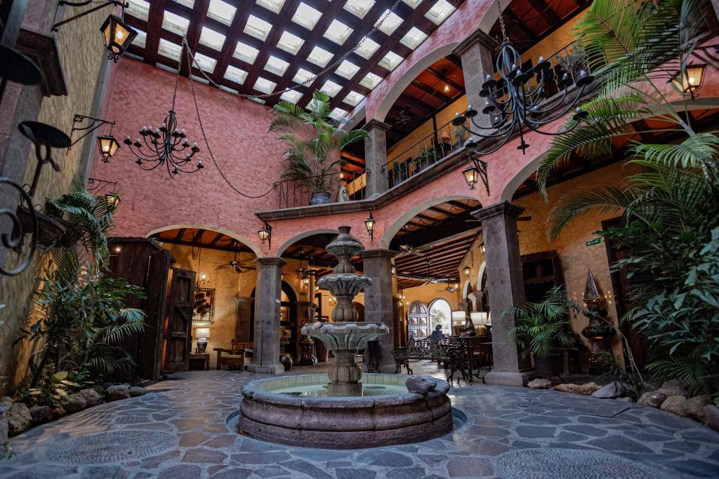 a large building with a fountain in the middle at Posada de las Flores Loreto in Loreto