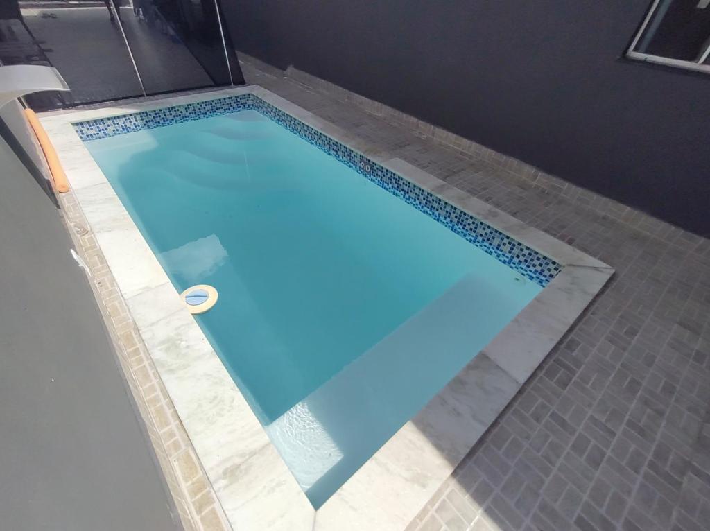 a blue swimming pool with a tile floor at Casa Paraíso Piscina Aquecida e Pet Friendly in Sinop