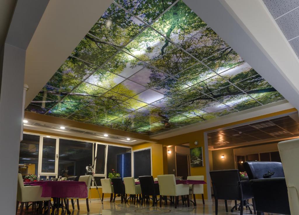 a dining room with a ceiling with flowers on it at Moon Cnter in Majdal Shams