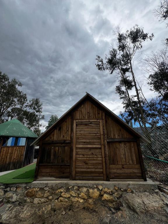 a small wooden building with a large door at Cabaña Bambú - Roca Glamping Suesca in Santa Isabel