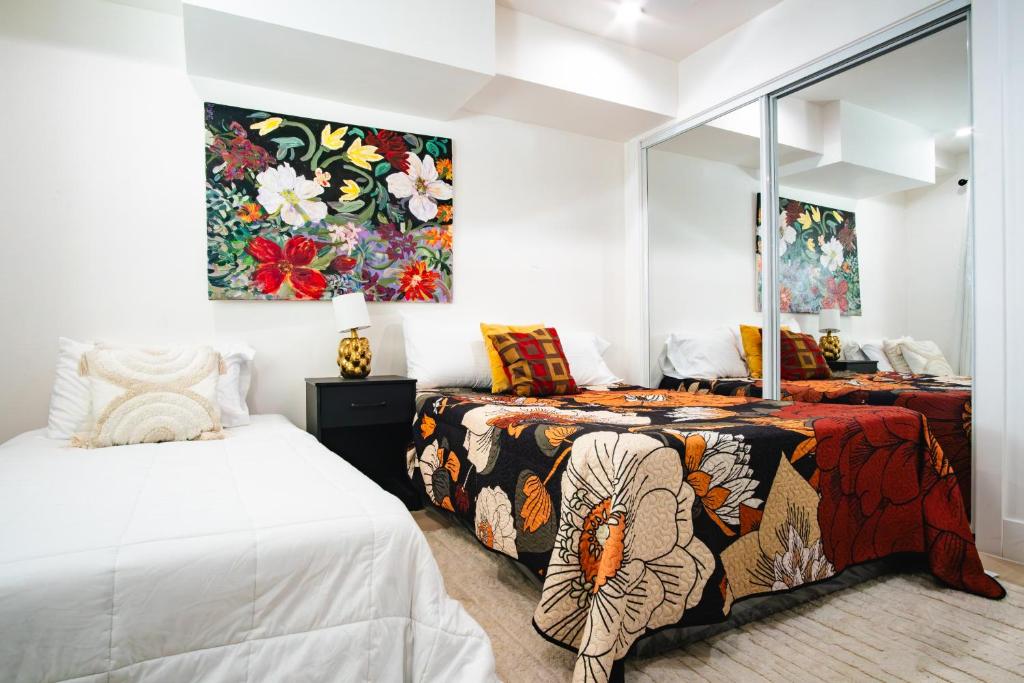 a bedroom with two beds and a painting on the wall at Jardin Noir at Case Collective in North Hollywood