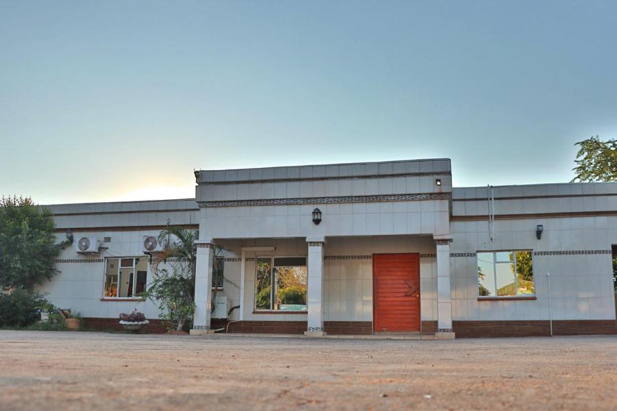 a large white building with a red door at Molejo Guest House in Palatswe