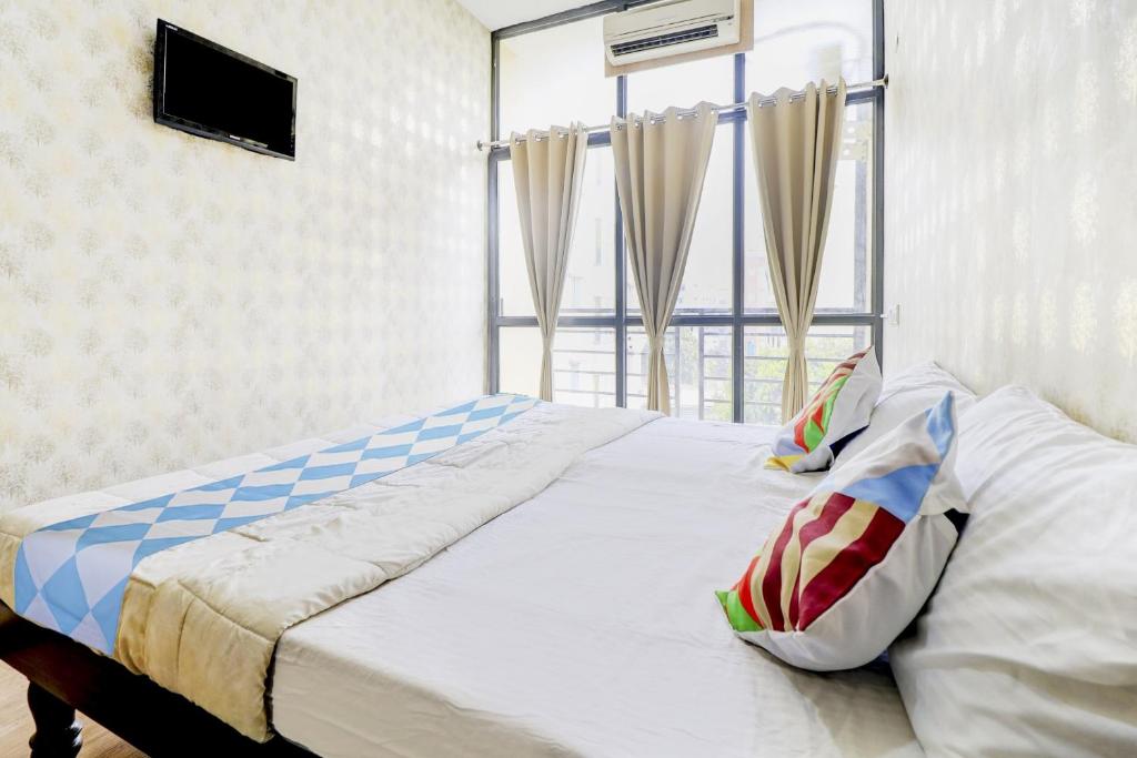 a bed in a room with a large window at Hotel O Together in Bangalore