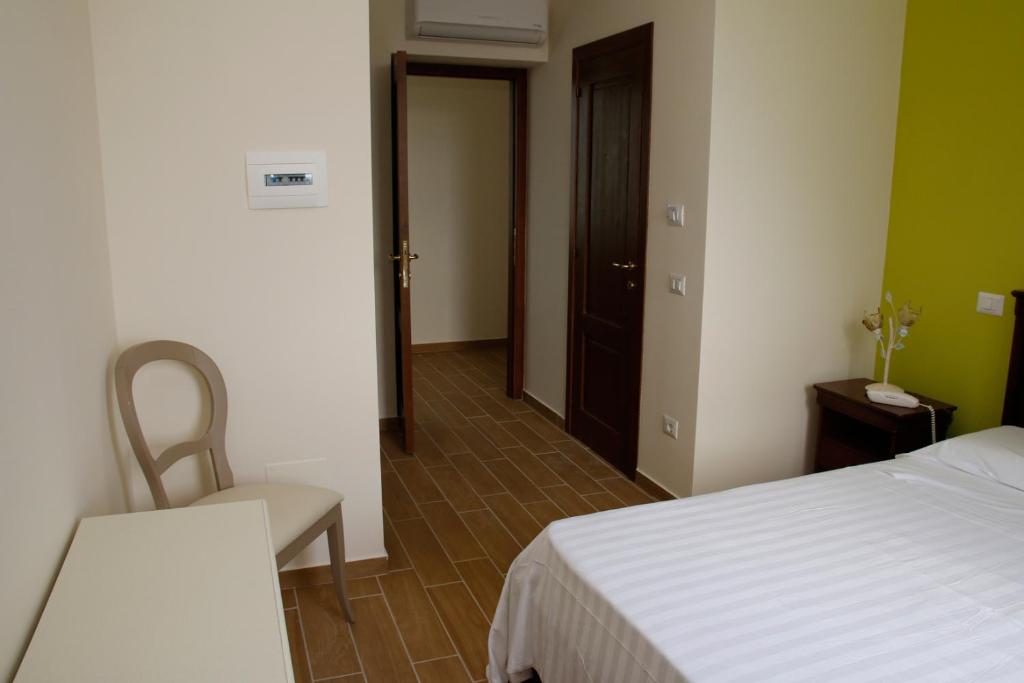 a bedroom with a bed and a chair and a door at Tenuta Cerreto in Calvi Vecchia