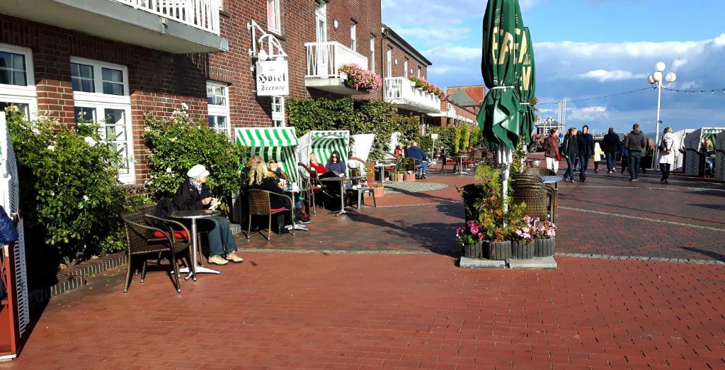 een groep mensen die aan tafels op straat zitten bij Hotel Seerose in Wilhelmshaven