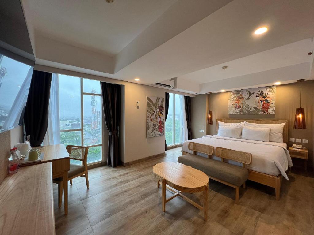 a hotel room with a bed and a desk and a television at Sahid Raya Hotel & Convention Yogyakarta in Yogyakarta