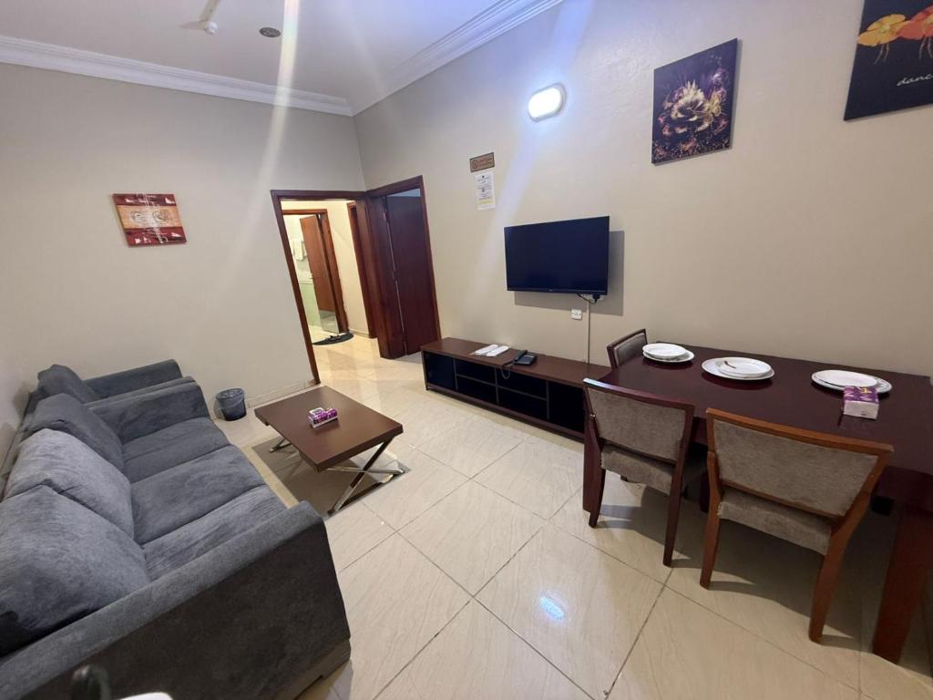 a living room with a couch and a table at شركه أركان الذهبيه الحديثه للشقق المخدومه in Abha