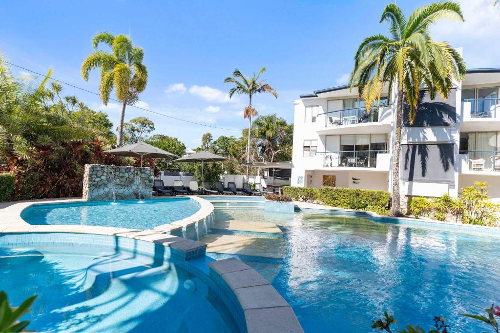 a swimming pool in front of a building at Immaculate Riverside Apartment With Heated Pool in Noosaville