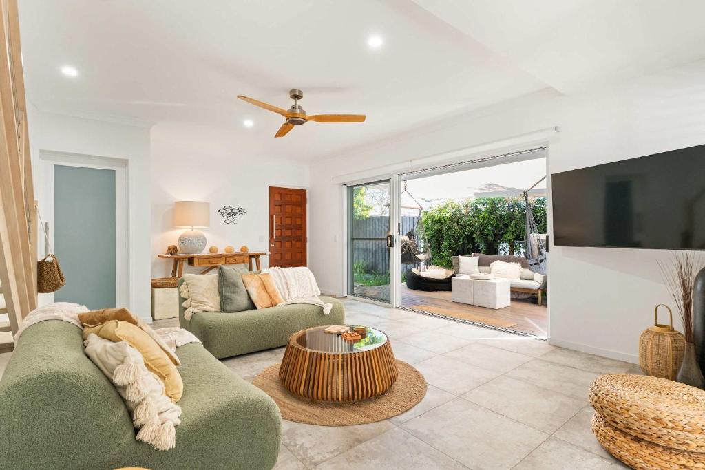 a living room with a couch and a table at Whispering Waves Pet Friendly Steps to Beach in Peregian Beach