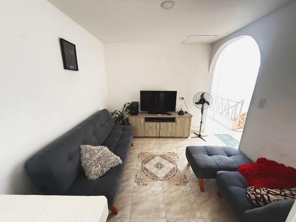 a living room with a couch and a tv at Casa Aire y Luz in Pereira