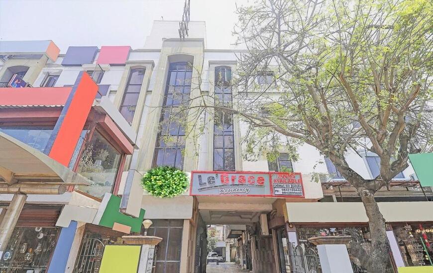 a tall building with a tree in front of it at Le Grace Annasalai in Chennai