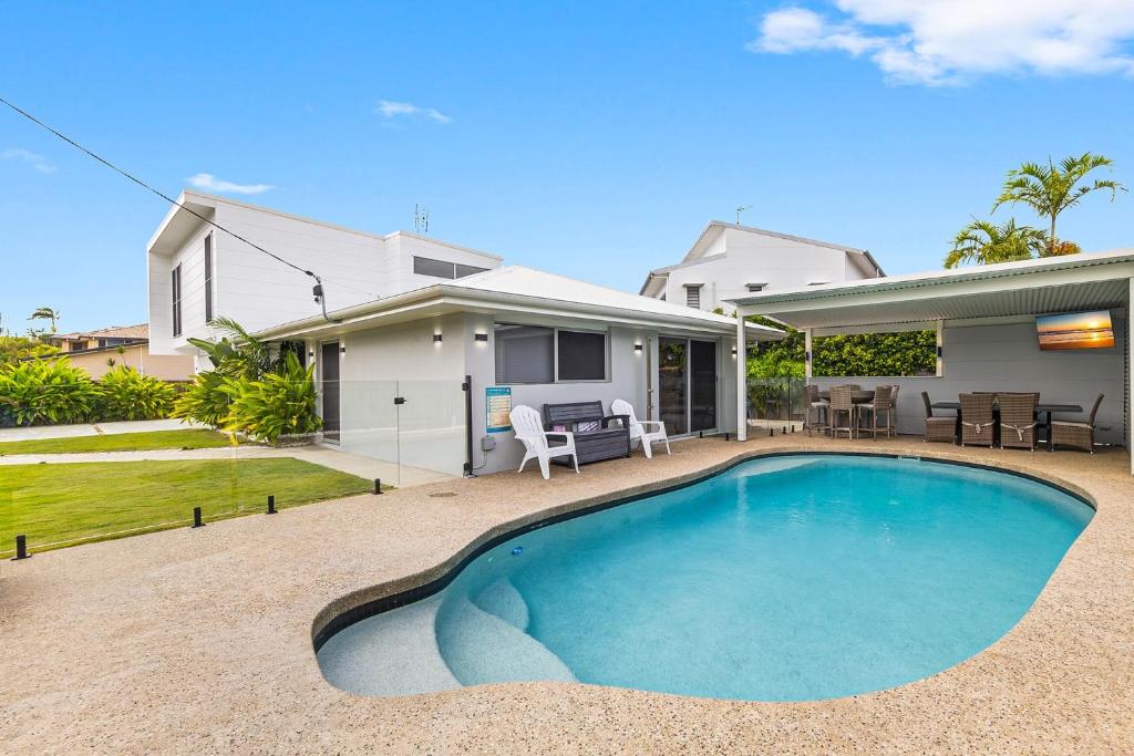 a swimming pool in the backyard of a house at Spacious 4-Bed Coastal Home with Pool in Mooloolaba