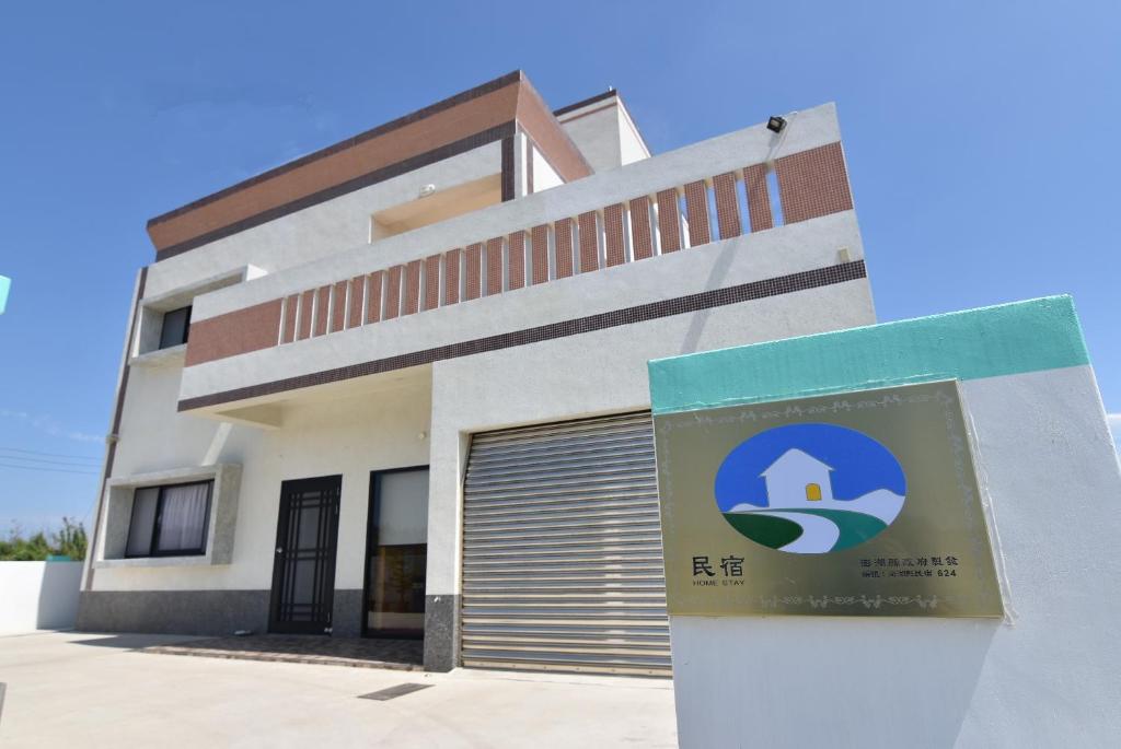 a building with a sign in front of it at Homelike Homestay in Huxi