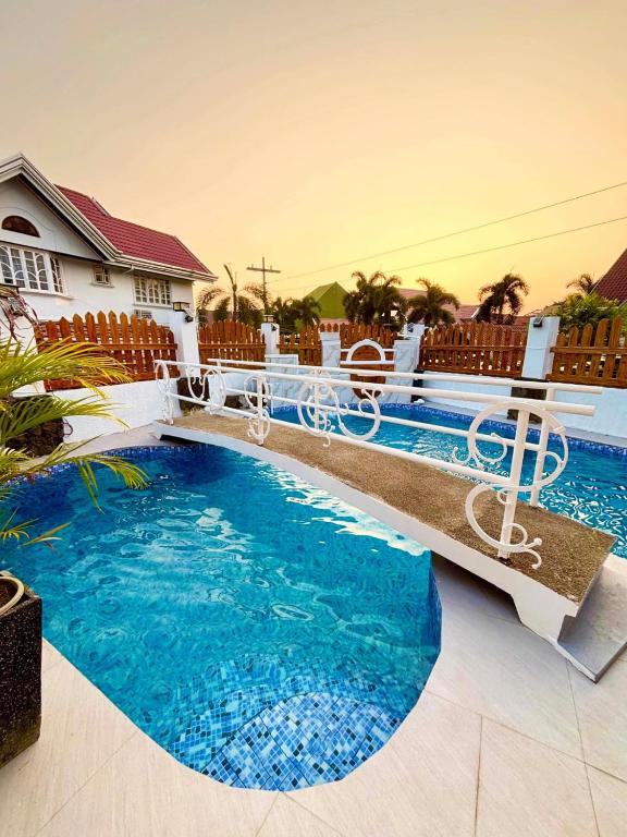 a swimming pool in front of a house at Hotel Adelina Balanga City Bataan in Balanga
