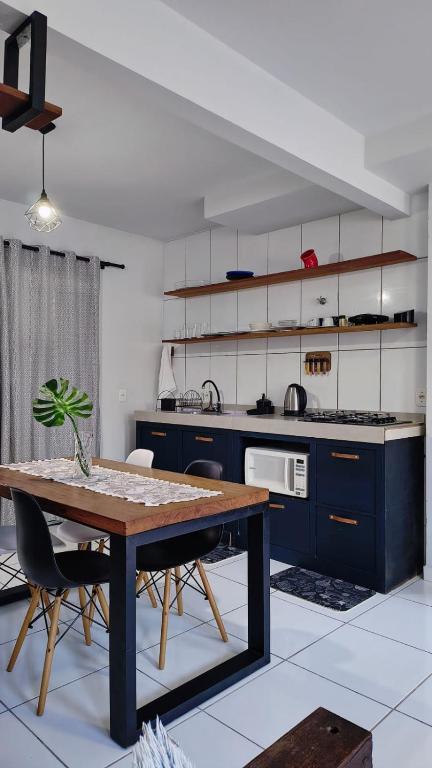 a kitchen with a wooden table in a kitchen at Aconchego e Estilo em Brusque in Brusque