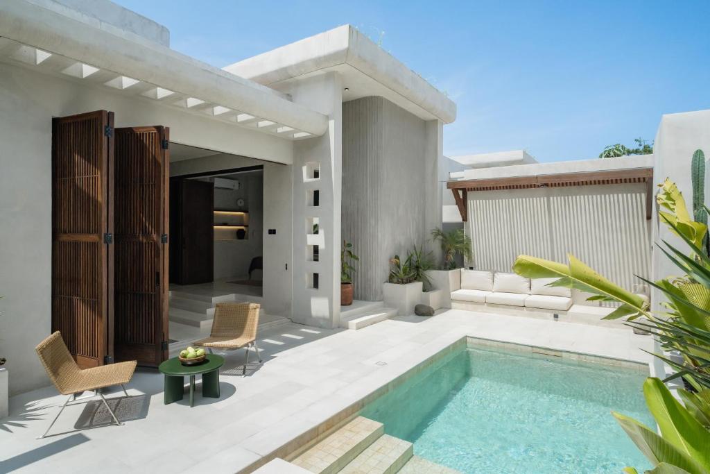 a villa with a swimming pool in a backyard at Heritage Villas in Uluwatu
