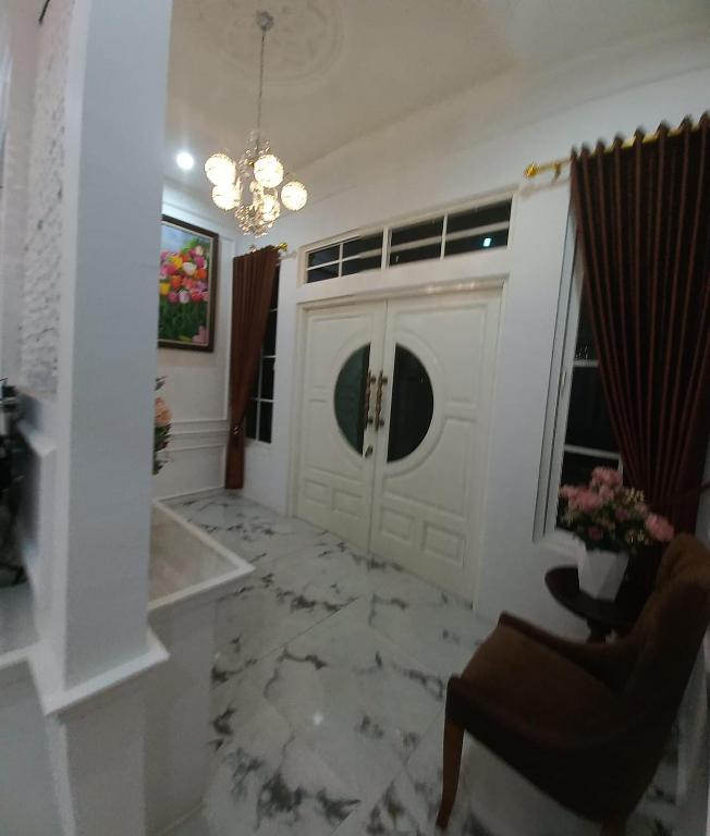 a living room with a white door and a chair at Batu Villa Sakura in Batu
