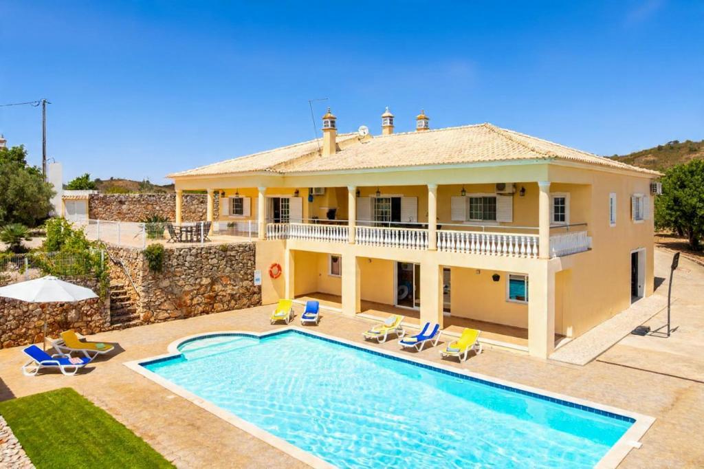 a villa with a swimming pool and a house at Villa Entrecolinas in São Bartolomeu de Messines