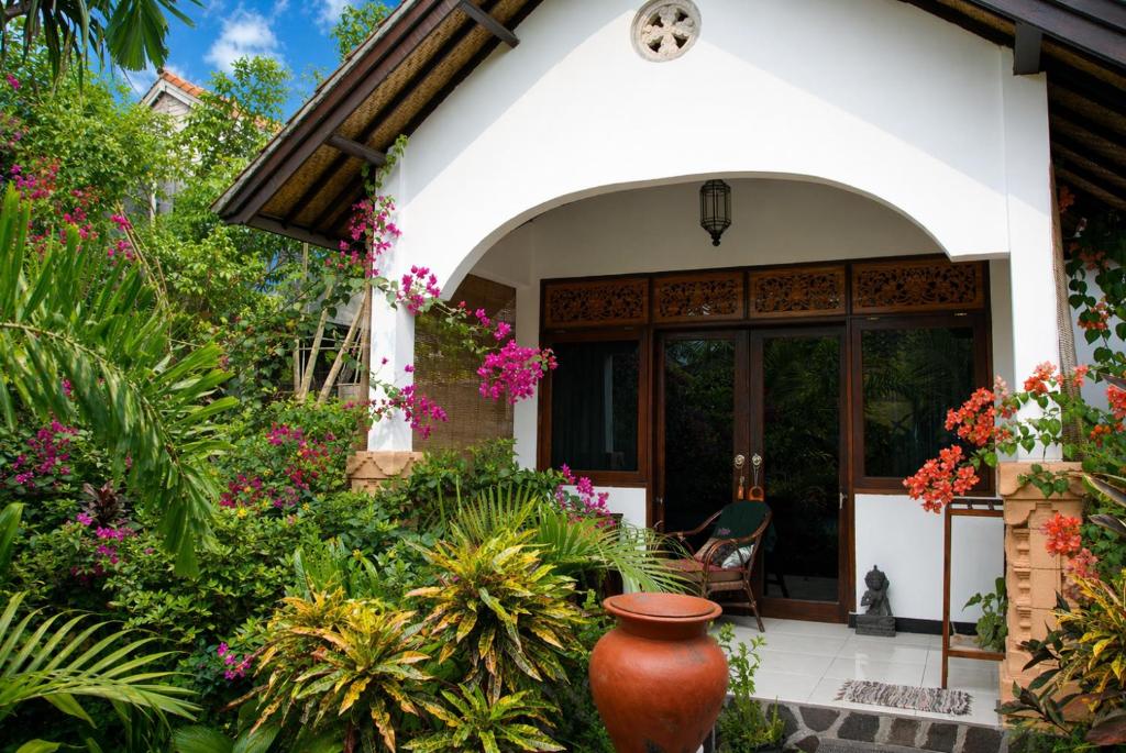a home with a large vase in the garden at Gili Nyepi in Gili Trawangan