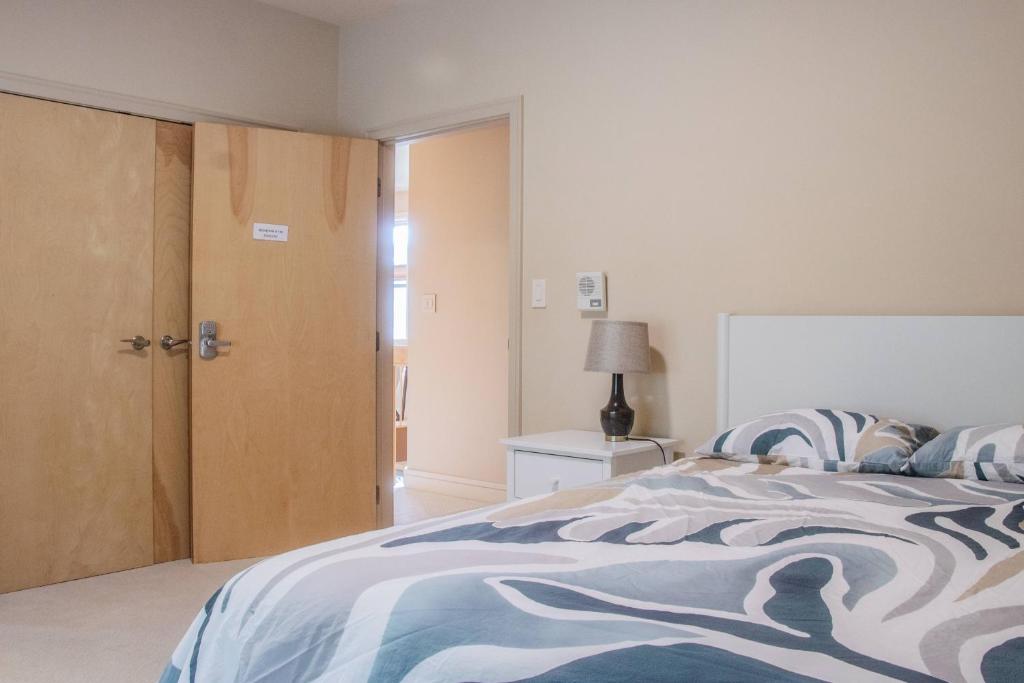 a bedroom with a bed with a blue and white blanket at Quiet Private Room with Ensuite - Broadmead 908 in Victoria