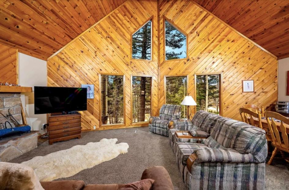 a living room with couches and a flat screen tv at Charming 3-bedroom Angel Fire Cabin in Angel Fire