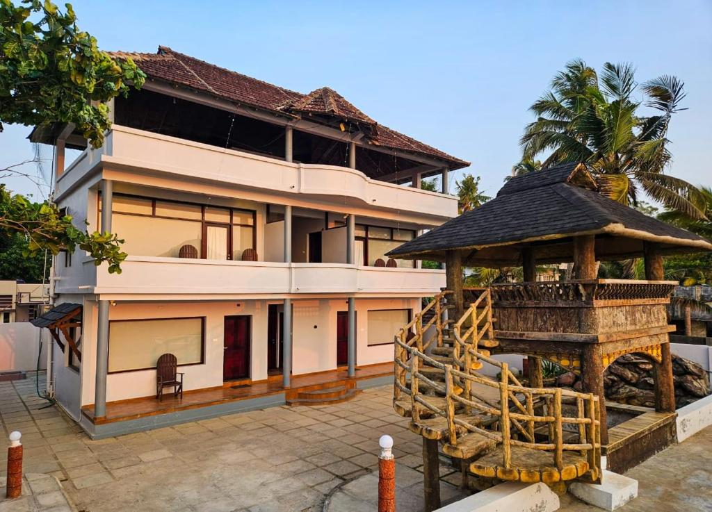 a house with a gazebo in front of it at Sea View Balcony room - Tide End Beach Villa in Pallipuram