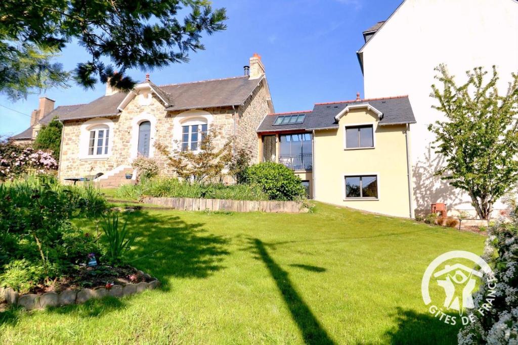 a large stone house with a grass yard at Le cerisier in Cancale