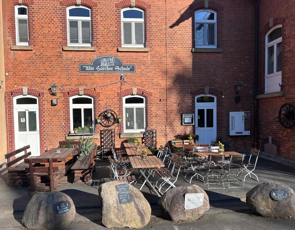 a restaurant with tables and chairs in front of a brick building at Alte Harcher Schule in Harra