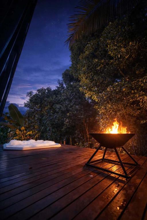 a fire pit on a wooden deck at night at Chalé Moov in Guarapari