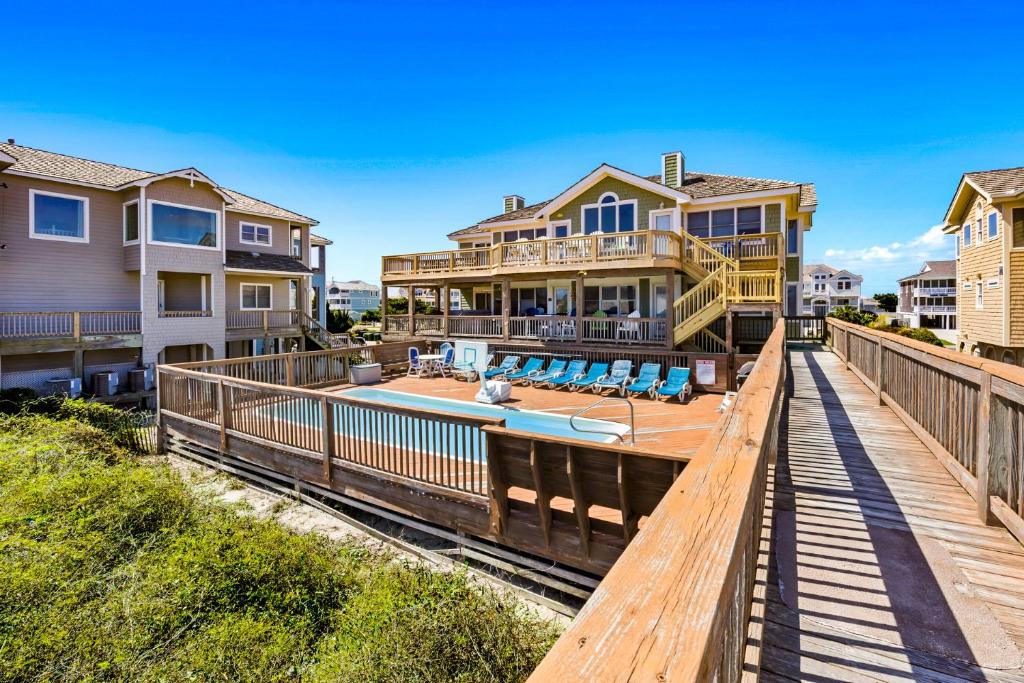 a boardwalk leading to a house with a swimming pool at 6119 - Gone Coastal in Nags Head