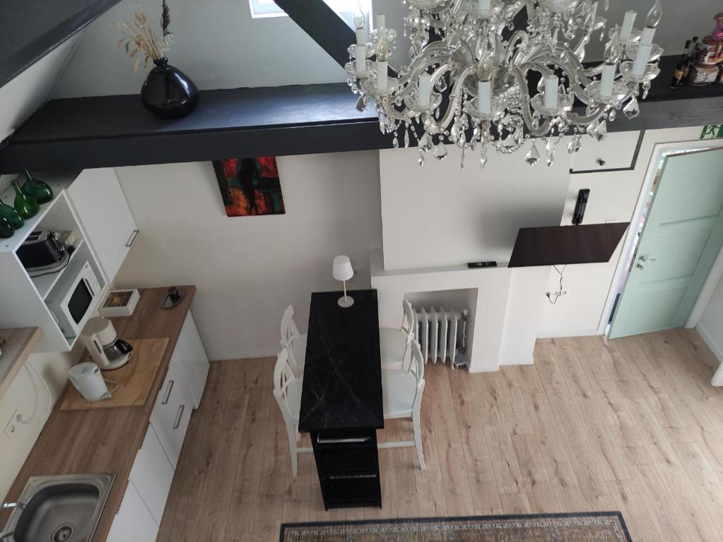 a kitchen with a table and chairs and a chandelier at Huma2025 in Eede