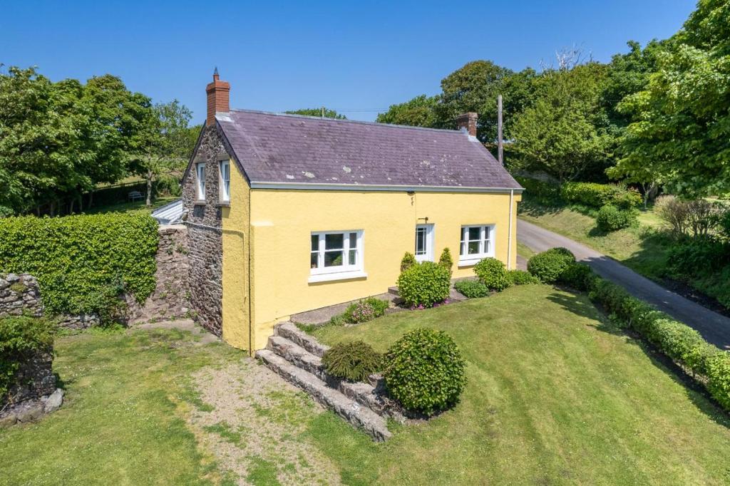 a yellow house with a garden in front of it at 4 Bed in St. Brides oc-h30490 in Saint Brides