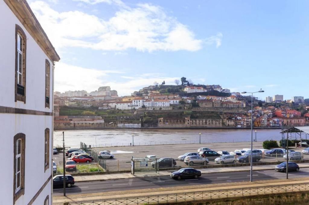 a parking lot with cars parked next to a river at Goabio Apartment 3 Riverview in Porto